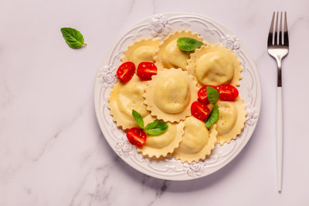 Ravioli with tomato sauce and basil on white plate.の写真素材