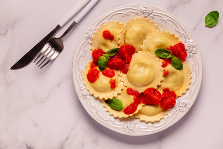 Ravioli with tomato sauce and basil on white plate.の写真素材