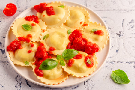 Ravioli with tomato sauce and basil on white plate.の写真素材