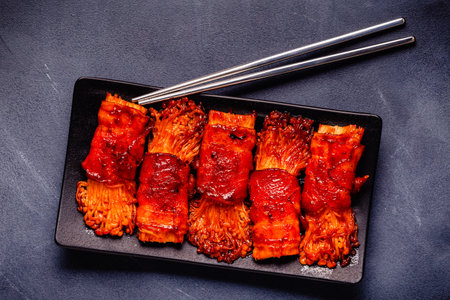 Bacon roll with enoki mushroom grilled with sauce in Japanese style.の写真素材