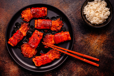 Bacon roll with enoki mushroom grilled with sauce in Japanese style.の写真素材