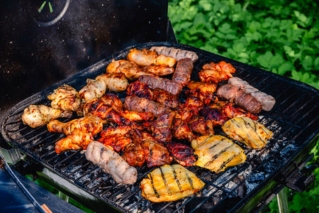 Different types of grilled meat on charcoal grill.の写真素材