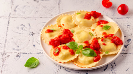 Ravioli with tomato sauce and basil on white plate.の写真素材