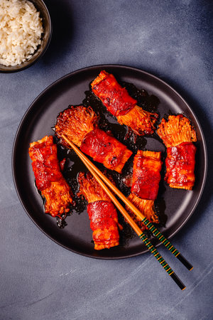 Bacon roll with enoki mushroom grilled with sauce in Japanese style.の写真素材