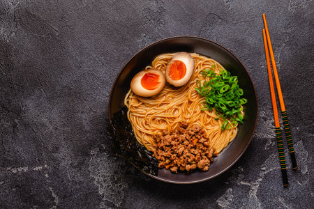 A bowl of ramen with noodles, meat and green onions, top view.の写真素材