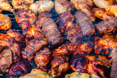 Different types of grilled meat on charcoal grill.の写真素材