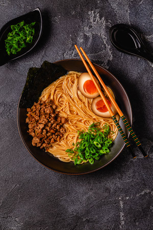 A bowl of ramen with noodles, meat and green onions, top view.の写真素材