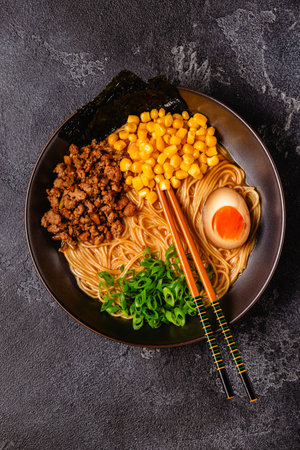 A bowl of ramen with noodles, meat and green onions, top view.の写真素材