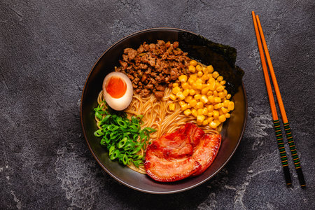 A bowl of ramen with noodles, meat and green onions, top view.の写真素材