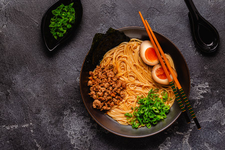 A bowl of ramen with noodles, meat and green onions, top view.の写真素材