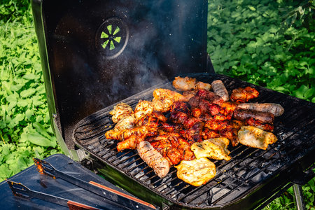 Different types of grilled meat on charcoal grill.の写真素材