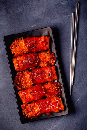 Bacon roll with enoki mushroom grilled with sauce in Japanese style.の写真素材