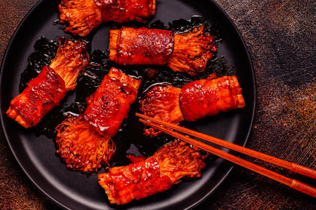 Bacon roll with enoki mushroom grilled with sauce in Japanese style.の写真素材