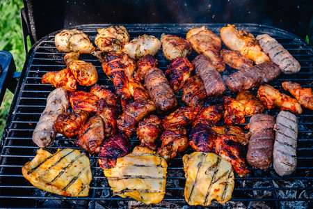 Different types of grilled meat on charcoal grill.の写真素材