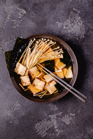 Asian-style soup with squid, tofu and enoki mushrooms. Top view.の写真素材