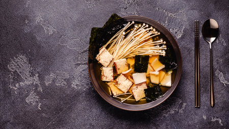 Asian-style soup with squid, tofu and enoki mushrooms. Top view.の写真素材