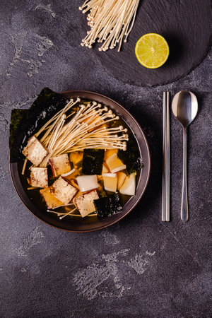 Asian-style soup with squid, tofu and enoki mushrooms. Top view.の写真素材