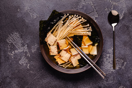 Asian-style soup with squid, tofu and enoki mushrooms. Top view.の写真素材