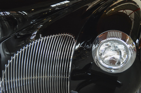 close up of a black classic car with headlight and grillの写真素材