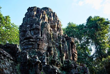 Historic building in Angkor wat Thom Cambodia with devatas carvings stone faces serenity milk oceanの写真素材