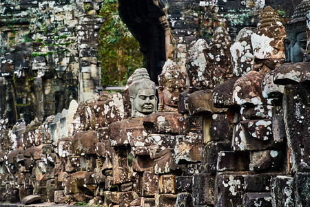 Historic building in Angkor wat Thom Cambodia with devatas carvings stone faces serenity milk oceanの写真素材