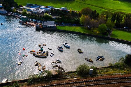 Fisherman boat harbour village in Wales, UK, england cloudy sky and green hillsの写真素材