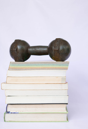 dumbbell on a books stackの写真素材