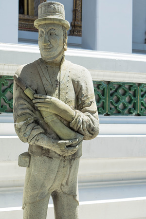 the ancient stone doll stand in a thailand templeの写真素材