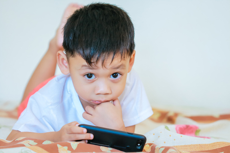 Children hands hold smartphone for playing and education.の写真素材