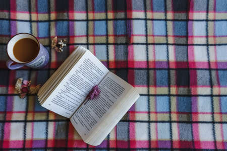 Purple coffe mug and a book with dried flowersの写真素材
