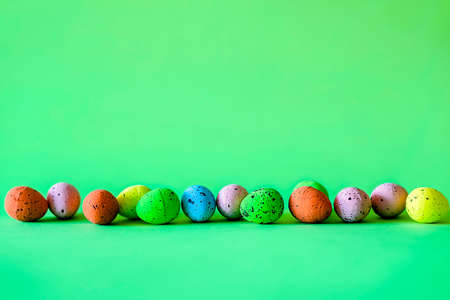 Horizontal border of colorful Easter eggs over green