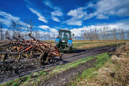 Seasonal agricultural works on tractor among the fieldsの写真素材