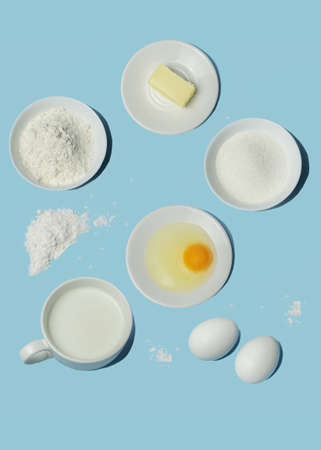 Vertical flatlay with baking ingredients on blue backdrop