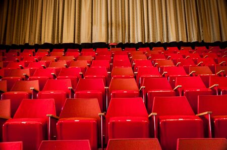 Rows of Red Seats in Cinema with Gold/Yellow Curtain