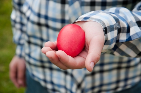 Red Easter egg in kid hand.