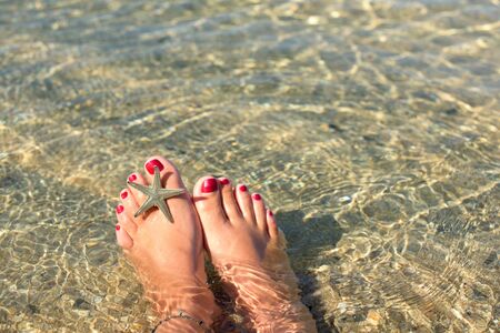 Female feet in a a sea waterの写真素材