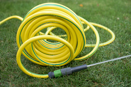 Yellow plasti hose pipe on a grassの写真素材