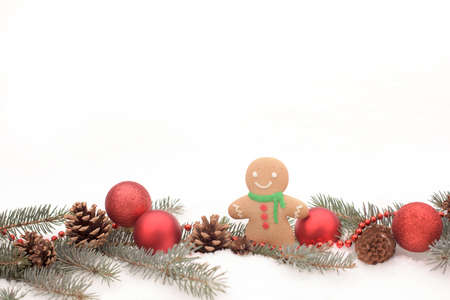 Christmas balls and ginger with fir branch and cones on a snowの写真素材