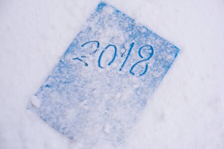 Sign in a snow- hand write 2018 on blue paper
