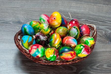 Full basket with colorful Easter hen eggs