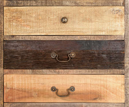 Old-fashioned wooden drawer bronze handles -part of an old wardrobe