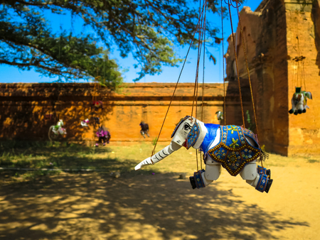 Ornamented elephant marionette puppet souvenir hanging under the big treeの写真素材