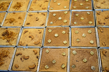 Fresh baked Khanom mo kaeng or Thai sweet delicious dessert in varieties of starch such as lotus seed, cashew nut, etc. in Nongmon local market, Chonburi, Thailandの写真素材