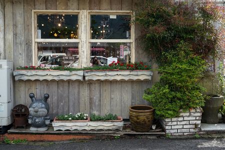 Yufuin, Japan - May 13, 2017 : Baikinman, the main antagonist  from popular anime Anpanman, granite stone sculpture standing in front of a shopfront along public walkway with flower and plant pot in yufuin, Kyushu, Japanのeditorial素材