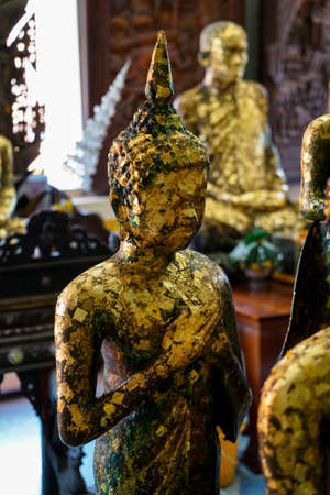 Old standing buddha image statue with Friday posture covered by gold leaf, Asokaram temple, Samutprakarnの写真素材