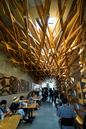 Dazaifu, Japan - May 14, 2017 :Beautiful interior decoration, natural light atmosphere of iconic Starbucks coffee store in Dazaifu with woven cedar wood full of customers, design by Kengo Kuma, famous Japanese architect, Dazaifu, Fukuoka, Kyushu, Japanのeditorial素材