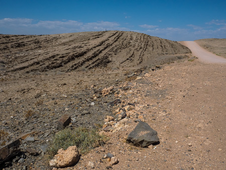 Beautiful day on adventure road trip through desert rock mountain texture landscape route to emptiness with blue sky copyspace background, Namibiaの写真素材