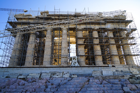Restoration work in progress at world heritage ancient Parthenon on marble base on top of Acropolis with machine crane,  scaffolding and blue sky background, Athens, Greeceの写真素材