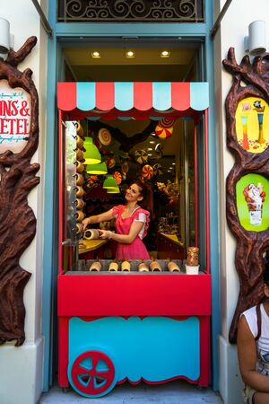 Athens, Greece - September 22, 2017: Colorful fairy tales theme shop front decoration of sweet shop with beautiful young lady seller smiling in pink dress, Monastiraki, Athensのeditorial素材