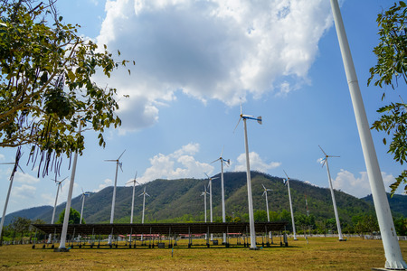 Windmill white post and solar cell panel technology to generate clean renewable energy on grass yard...